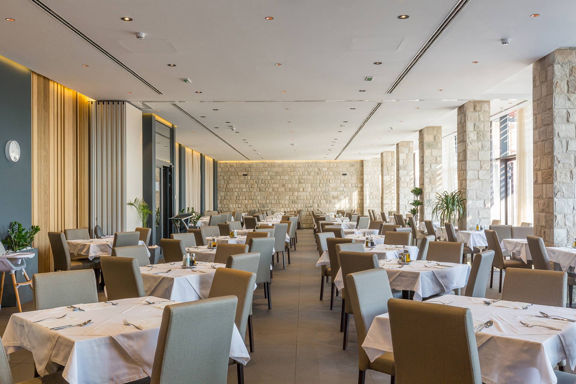 Salle de restaurant haut de gamme avec design moderne, pierres apparentes et ambiance chaleureuse – Rénovation et aménagement par AJLP RENOV'
