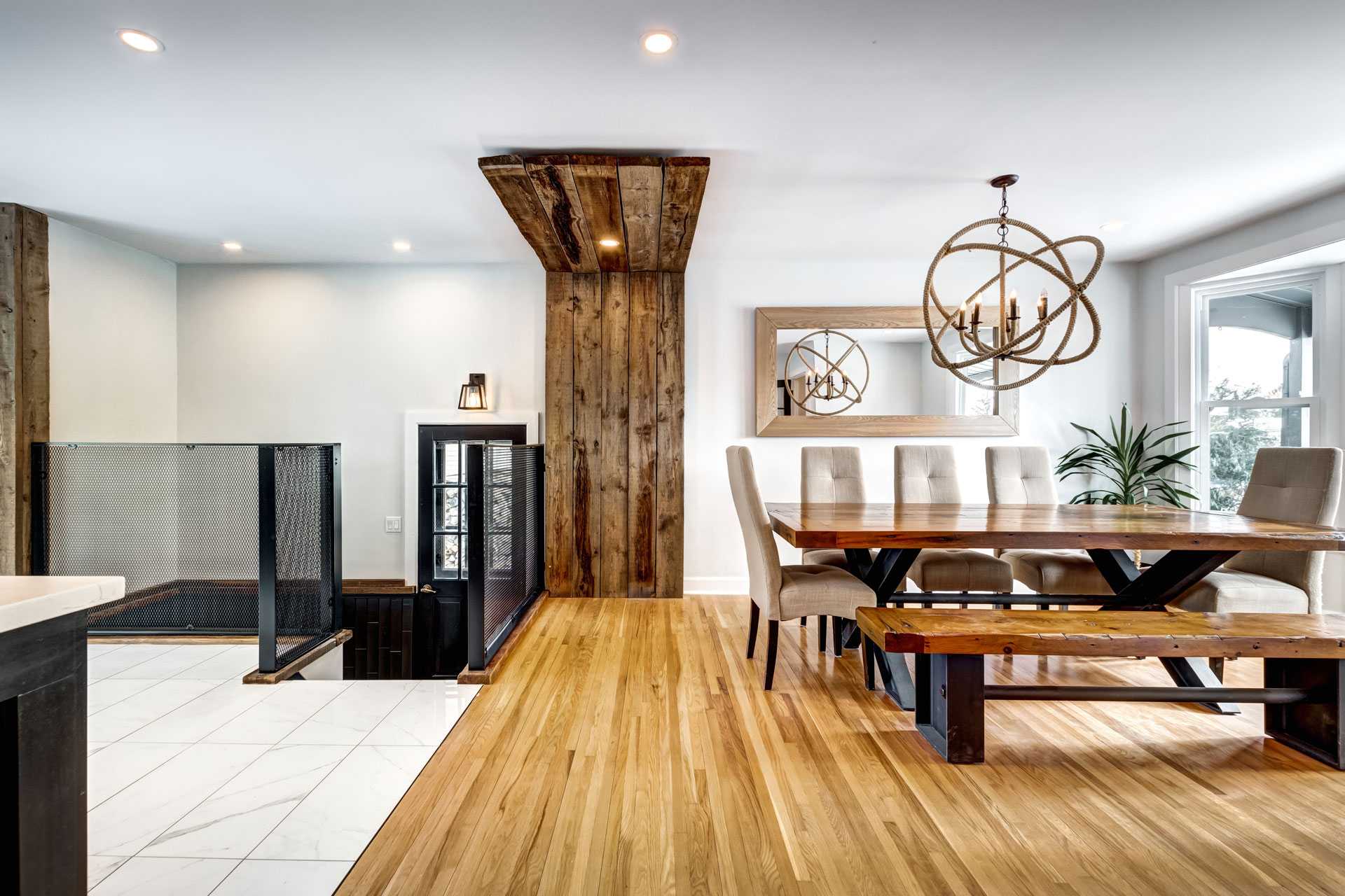 Salle à manger moderne rénovée avec parquet en bois, poutres apparentes et luminaires design – AJLP RENOV’, expert en rénovation intérieure pour maisons, appartements et entreprises.