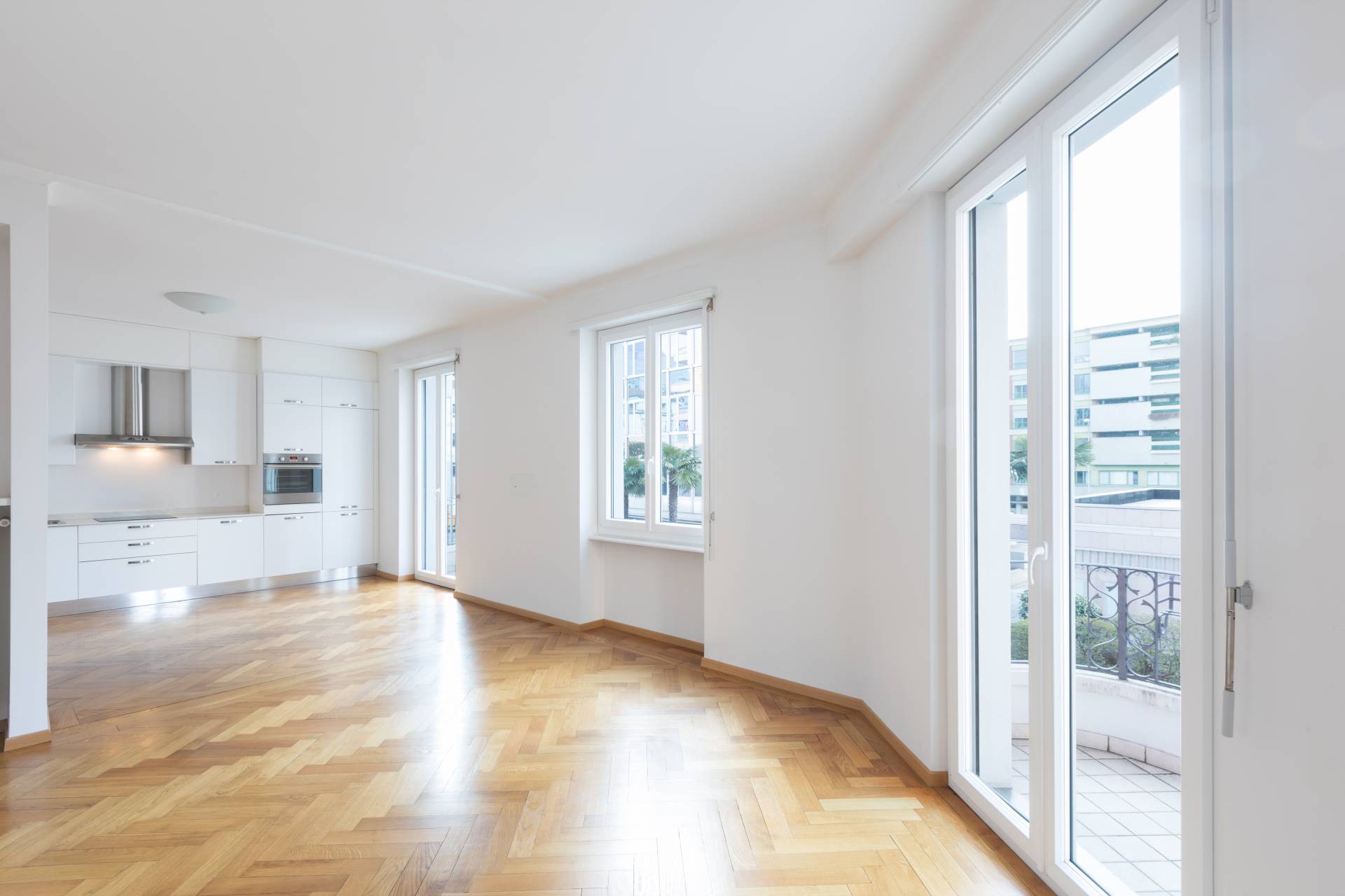 Appartement lumineux avec parquet en bois et cuisine moderne, idéal pour les partenariats en rénovation