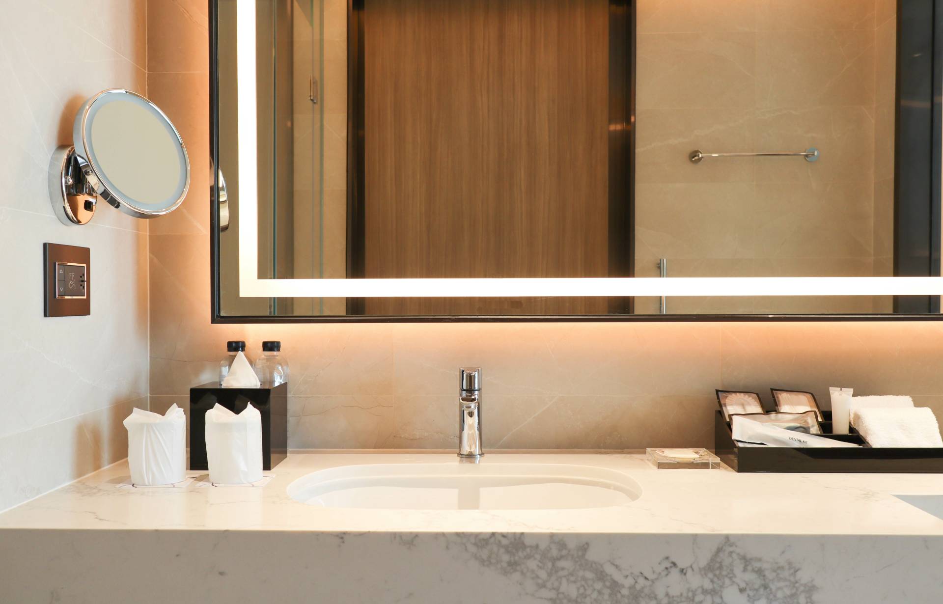 Salle de bain moderne avec lavabo en marbre, miroir éclairé et accessoires élégants